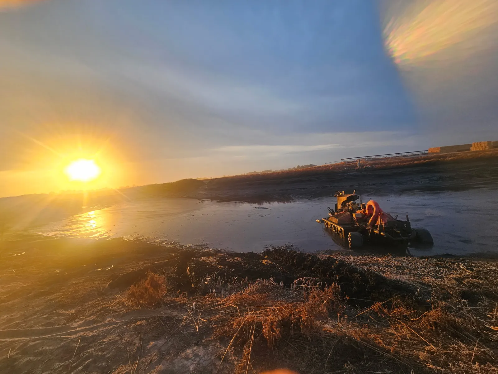 Pumping equipment working a dairy lagoon at sunset